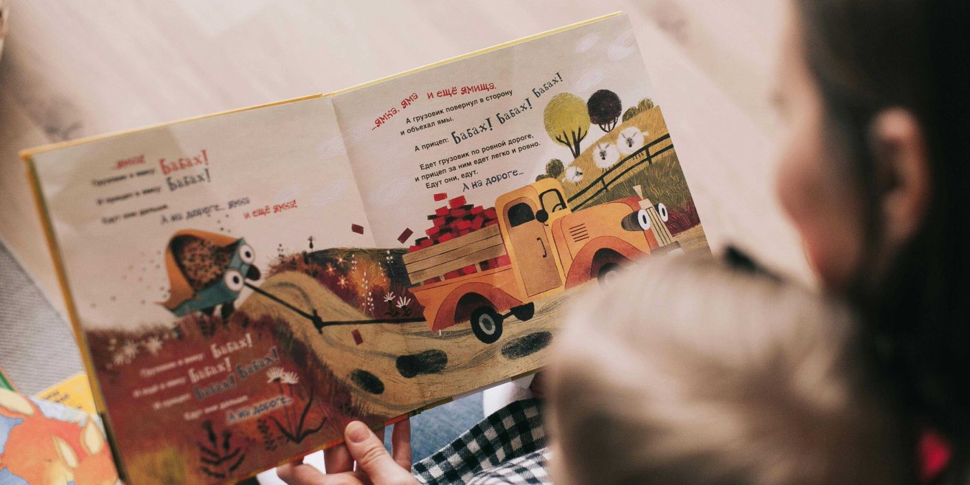 Pengasuh dan anak membaca buku cerita. (Lina Kiyaka - Pexels)